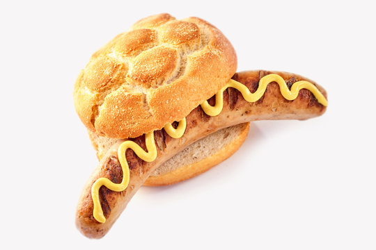 Seared sausage in a crusty bread bun with mustard