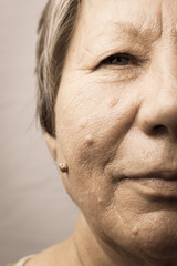 Obraz premium Elderly pensioner female half face portrait closeup