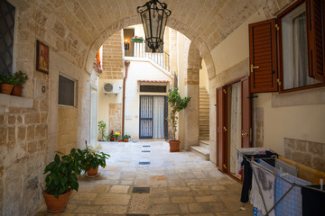 Fototapeta na wymiar View of a narrow sunny street in the city Bari, Italia