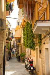 Fototapeta na wymiar View of a narrow sunny street in the city Bari, Italia