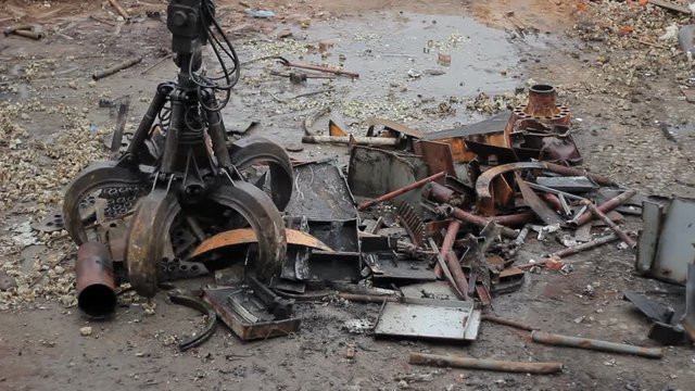 The excavator's hand raised metal scrap for recycling