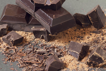 Macro slices of chocolate on a black background. Chocolate close-up.