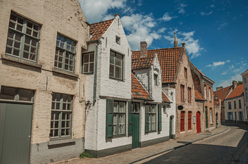 Fototapeta na wymiar Brick facade of houses in typical style of the Flanders’s region in street of Bruges. With many canals and old buildings, this graceful town is a World Heritage Site of Unesco. Northwestern Belgium.