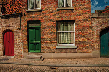 Fototapeta na wymiar Brick facade of houses in Flanders typical style at street of Bruges. With many canals and old buildings, this graceful town is a World Heritage Site of Unesco. Northwestern Belgium. Retouched photo