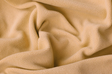 The blanket of furry orange fleece fabric. A background of light orange soft plush fleece material...