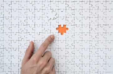 The texture of a white jigsaw puzzle in the assembled state with one missing element, forming an...