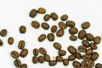 close up of medium or dark roasted coffee beans isolated on white background, can be used as a background or graphic object in your ads.