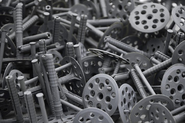 Background pattern of many gray plastic dowels fastening for thermal insulation. A huge pile of...