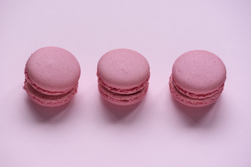Three pink macaroons on pink background