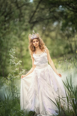 Fairy-tale princess in the crown in a magical forest. © Max