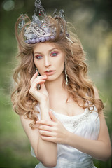 Fairy-tale princess in the crown in a magical forest. © Max