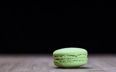 Green macaroon on wooden background