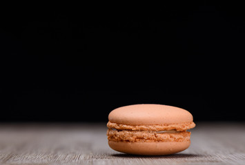 Orange macaroon on wooden background