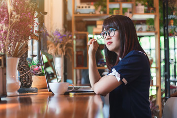 Asian young business woman working make a note of something making notes on in coffee shop like the background.