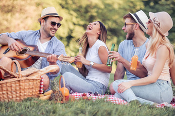 Happy young friends having picnic in the park