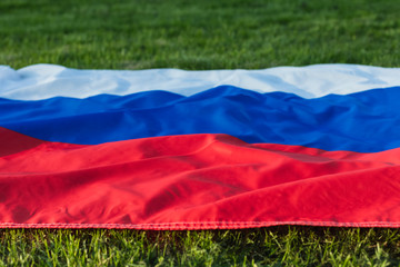 Russian flag lying on the green grass