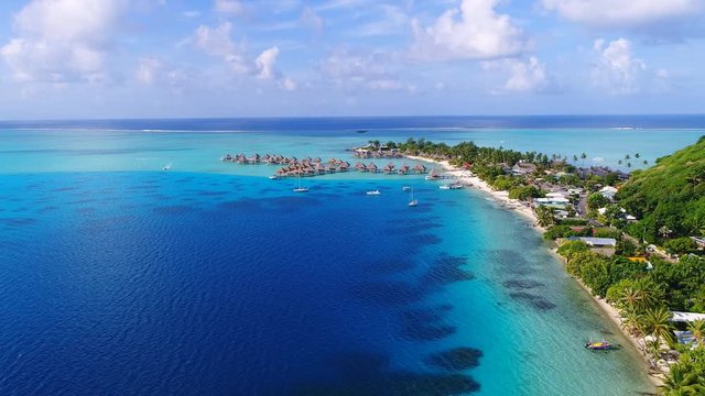 Aerial view of tropical paradise of Bora Bora island, turquoise crystal clear water of scenic blue lagoon, typical over water bungalows, Matira Point - South Pacific Ocean, French Polynesia from above