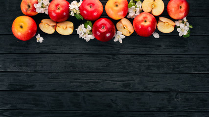 Fresh red apples with inflorescences and leaves. On a wooden background. Top view. Copy space.