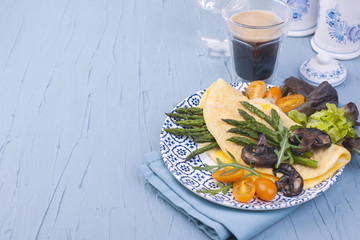 Healthy breakfast. Omelette with asparagus, mushrooms and salad. Vegan. Copy space . A glass with a fragrant black coffee.
