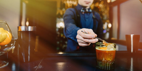 Expert Bartender is making cocktail at bar.