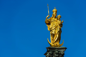 Fototapeta na wymiar Marian column (1639) or Mariensaule with golden statue of Virgin Mary, Munich, Germany