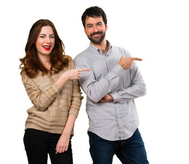 Young couple pointing to the lateral