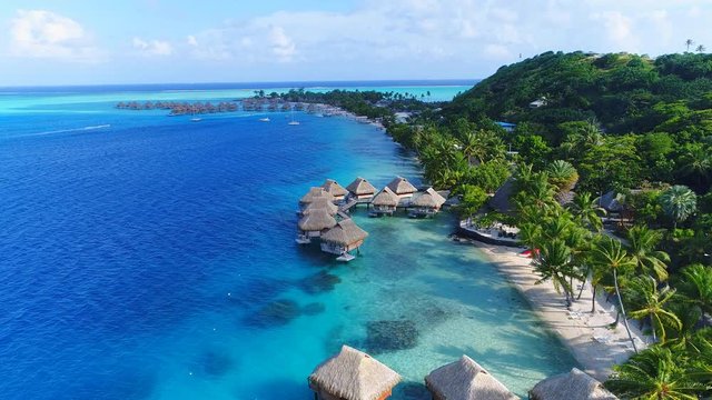 Aerial view of tropical paradise of Bora Bora island, turquoise crystal clear water of scenic blue lagoon, typical over water bungalows, Matira Point - South Pacific Ocean, French Polynesia from above