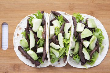 Mexican food. Carnitas street tacos in corn tortillas on wooden board. Top view.