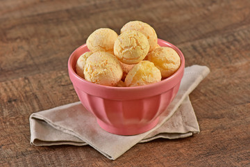 Cheese breads on pink bowl and wooden background
