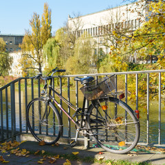 Fototapeta na wymiar A bicycle attached to the railing of the bridge across the river Isar, Munich, Germany