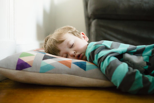 Tired boy sleeping on floor at home