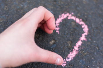 Child hand shows heart gesture