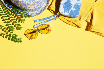 Summer fashion clothing and accessories on yellow background, trendy tropical fashion item flat lay 