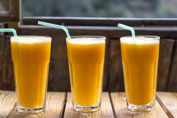 orange juice on wooden background infront of window