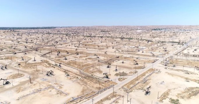 Aerial view of oil field, pumpjack. Aerial of oil pumps in desert - August 2017: Bakersfield, California, US