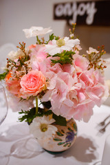 Dining table setting at Provence style, with candles, lavender, vintage crockery and cutlery, closeup. Beautiful wedding decoration with flowers pink violet purple white colors