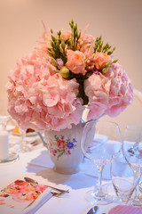Dining table setting at Provence style, with candles, lavender, vintage crockery and cutlery, closeup. Beautiful wedding decoration with flowers pink violet purple white colors
