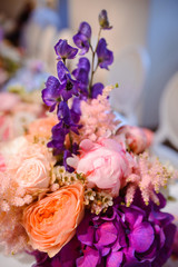 Dining table setting at Provence style, with candles, lavender, vintage crockery and cutlery, closeup. Beautiful wedding decoration with flowers pink violet purple white colors