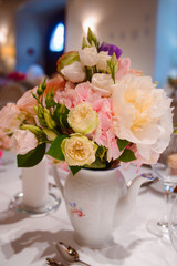 Dining table setting at Provence style, with candles, lavender, vintage crockery and cutlery, closeup. Beautiful wedding decoration with flowers pink violet purple white colors