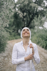 woman with white headscarf in the forest, has cancer