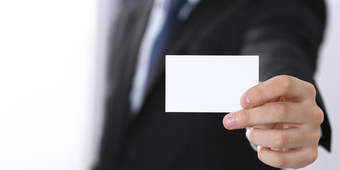 Businessman's hand holding business card with empty space