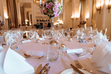 Luxurious luxury restaurant hall prepared for wedding dinner. Serving. Table appointment catering. Summer party. Preparing for reception or dance