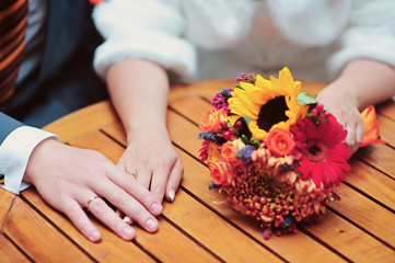 Obraz na płótnie Canvas Autumn wedding bouquet and hands of beautiful wedding couple. Love and tenderness concept close up photo with selective focus