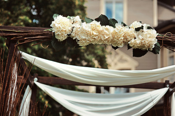Rustic wedding decoration with flowers and branches. Flowers in a mason jar a wedding ceremony. Seating guests. Wedding ceremony details. Selective focus wedding celebration party reception catering