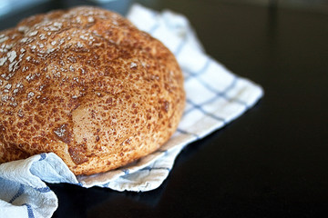 Freshly tasty baked bread with white towel and black background.