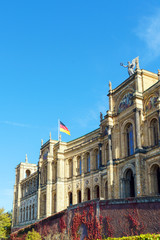 Obraz premium Waving German flag above The Maximilianeum (1874), seat of Bavarian Landtag, Munich, Germany