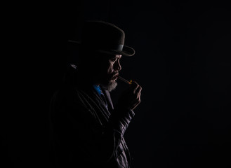 Fototapeta na wymiar dark portrait, smoking man, black studio background
