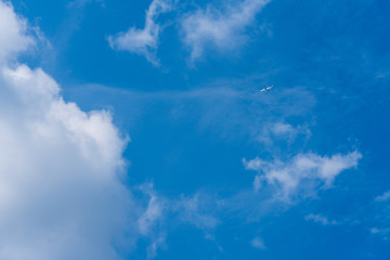 Fototapeta na wymiar Flugzeug am Himmel mit Wolken