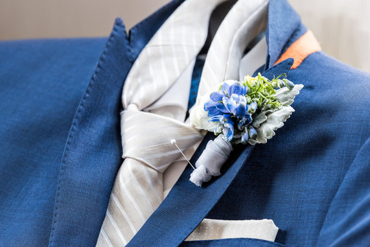 Men's new marine navy blue suit and tie groom closeup with flower boutonniere, pin getting ready wedding preparation isolated, pocket handkerchief