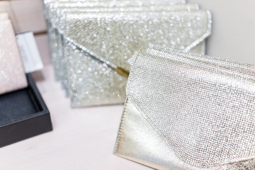 Closeup of wedding luxury expensive shiny white purses in boutique discount store, many selection on shelf display with glittering rhinestones